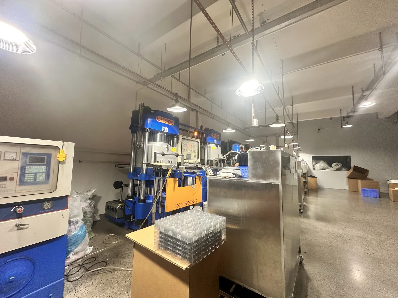 Blue molding presses and workstations on the production floor